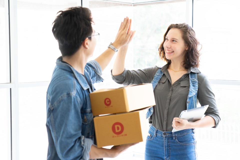 Duo d’entrepreneurs célébrant une livraison réussie illustrant le dropshipping salaire